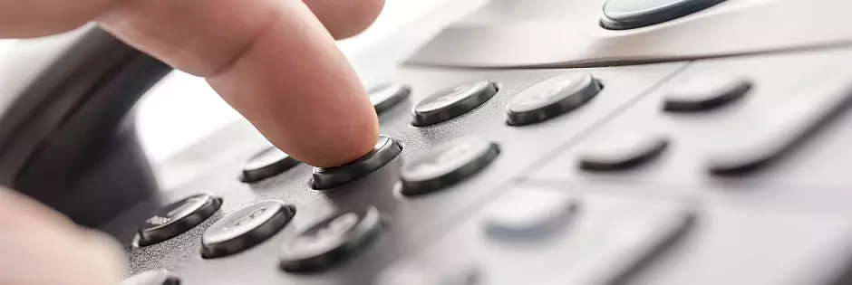 Eine Hand whlt eine Nummer auf einem Telefon